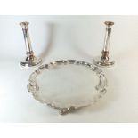A silver plated pie crust edge circular tray on claw and ball feet with a pair of silver plated