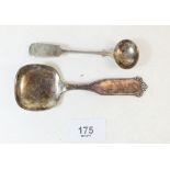 A silver salt spoon and a white metal continental caddy spoon