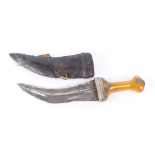 Eastern jambiya with white metal mounts and amber hilt, in leather sheath