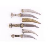 Three Eastern style knives, all with typically decorated grips white metal detail and metal