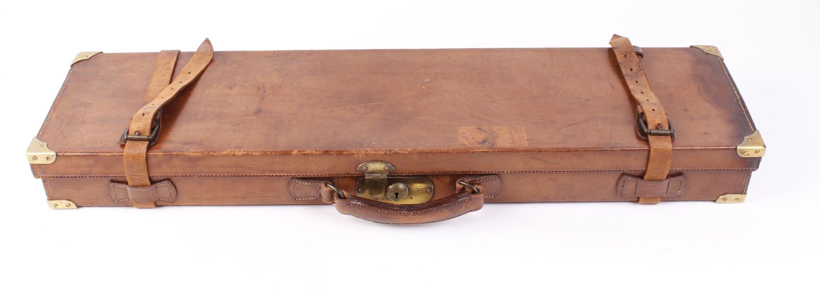Leather gun case with brass corners, claret baize lined fitted interior for 30 ins barrels, H.