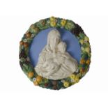 An early 20th Century Della Robbia type majolica roundel, the centre with the virgin and child in