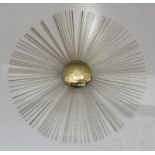 A contemporary wall mounted gilt metal sculpture of a sunburst after a design by Jonathan Adler,