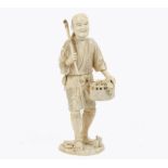 A Meiji period carved ivory figure of a farmer holding a scythe and basket of fruit and