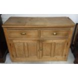 A 19th Century waxed pine dresser base, two short drawers over two panel doors, 131 cm wide x 51