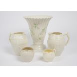 A group of Belleek porcelain, including a 3rd period milk jug, a ribbed flared vase on square base