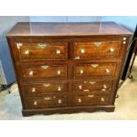 A late 18th Century oak and ebonised strung chest, eight short drawers, brass pulls, shaped plinth