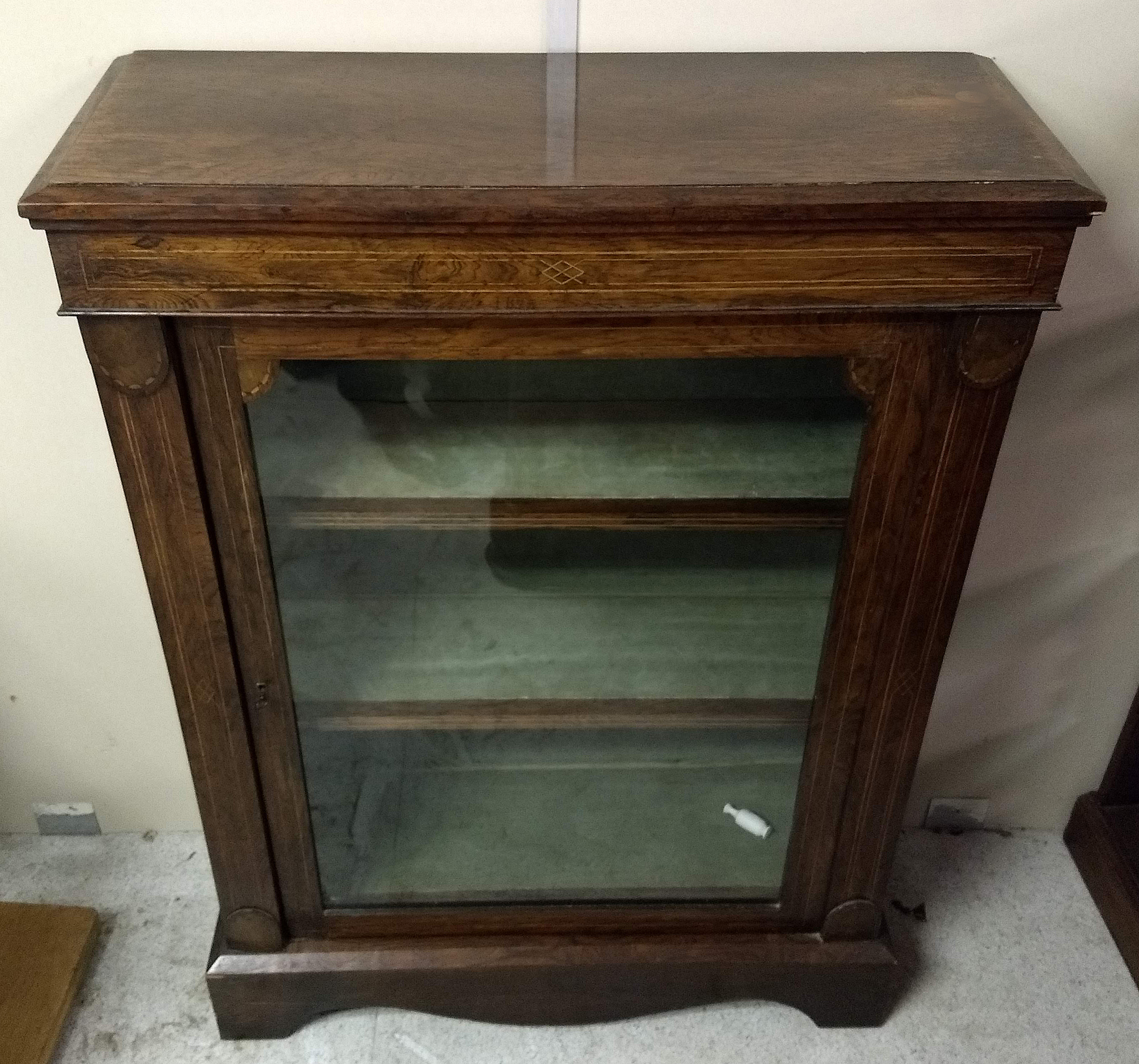 A 19th Century rosewood and inlaid pier cabinet, single glazed door, two fixed shelves, green velvet