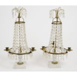 A pair of glass table candelabras, three brass arms, graduated glass prism drops surrounding brass