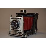 A Graflex Century Graphic 2¼ x 3¼" Press Camera, serial no 528250, red bellows with a Rodenstock