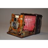 A Sanderson Regular Model Hand and Stand Folding Plate Camera, red bellows, serial no 13684, 3¼" x