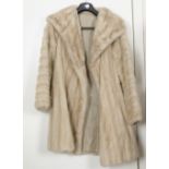 A mid 20th Century fur three-quarter length coat, possibly ermine, the grey silk lining bearing