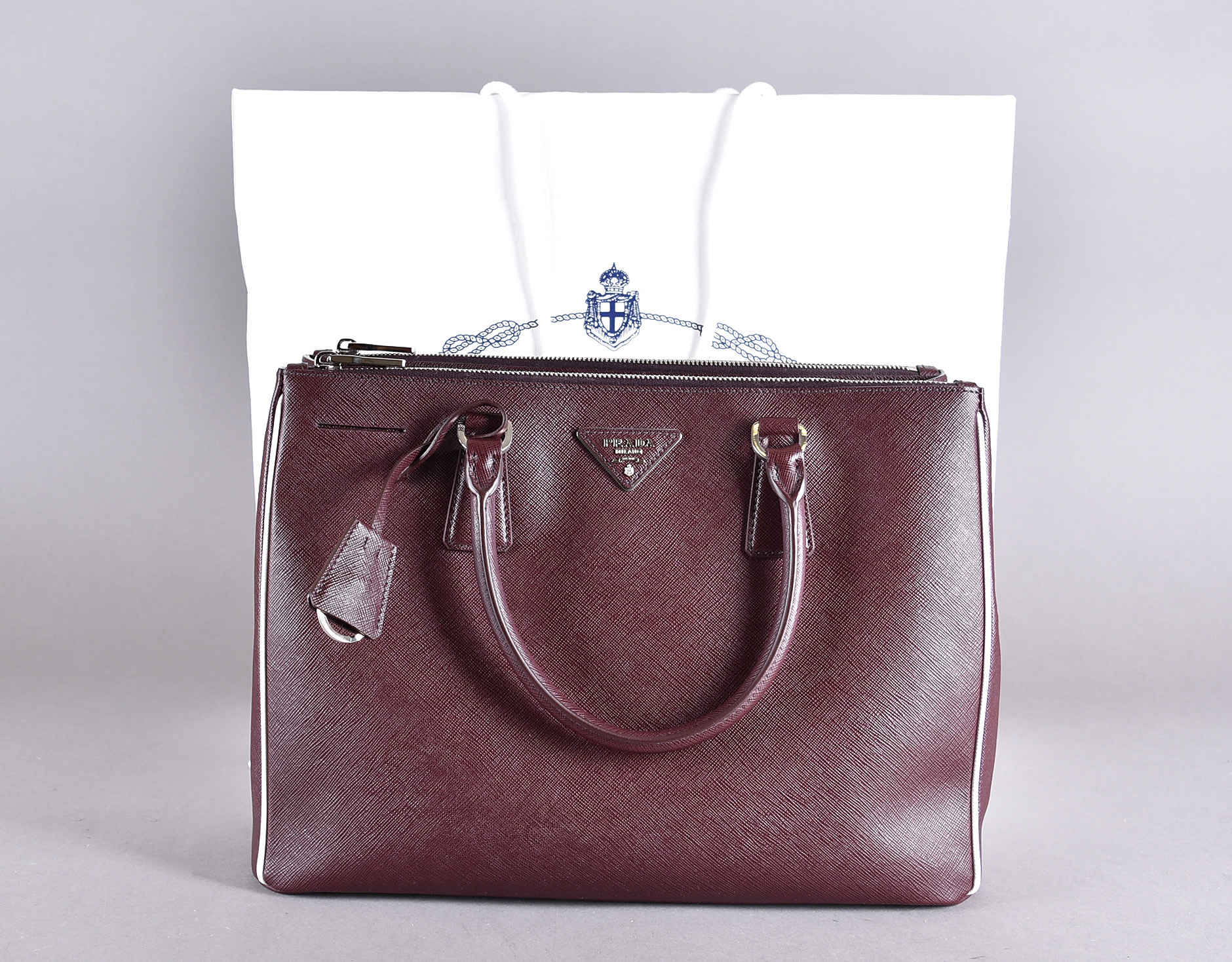 A Prada Milano Saffiano Lux hand bag, in 'Granato and Talc' with original sleeve, and carryout