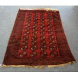 A Middle-Eastern woollen rug, 44 geometric guls on red ground, red and black geometric border, 198