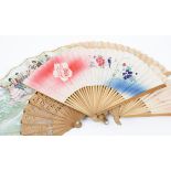 A 20th Century folding fan, wooden guards and sticks cloute and carved with flowers, double paper
