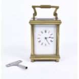 An early 20th Century carriage timepiece, in a brass metal case with top mounted swing handle,