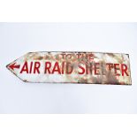 A WWII 'To The Air Raid Shelter' enamel sign, having red text on white ground, approx 60.5cm long,