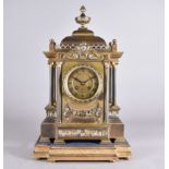 A W Gibson & Co lacquered brass architectural mantel clock having floral swag, egg and dart design