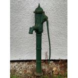 A green painted cast iron water pump, domed top with finial