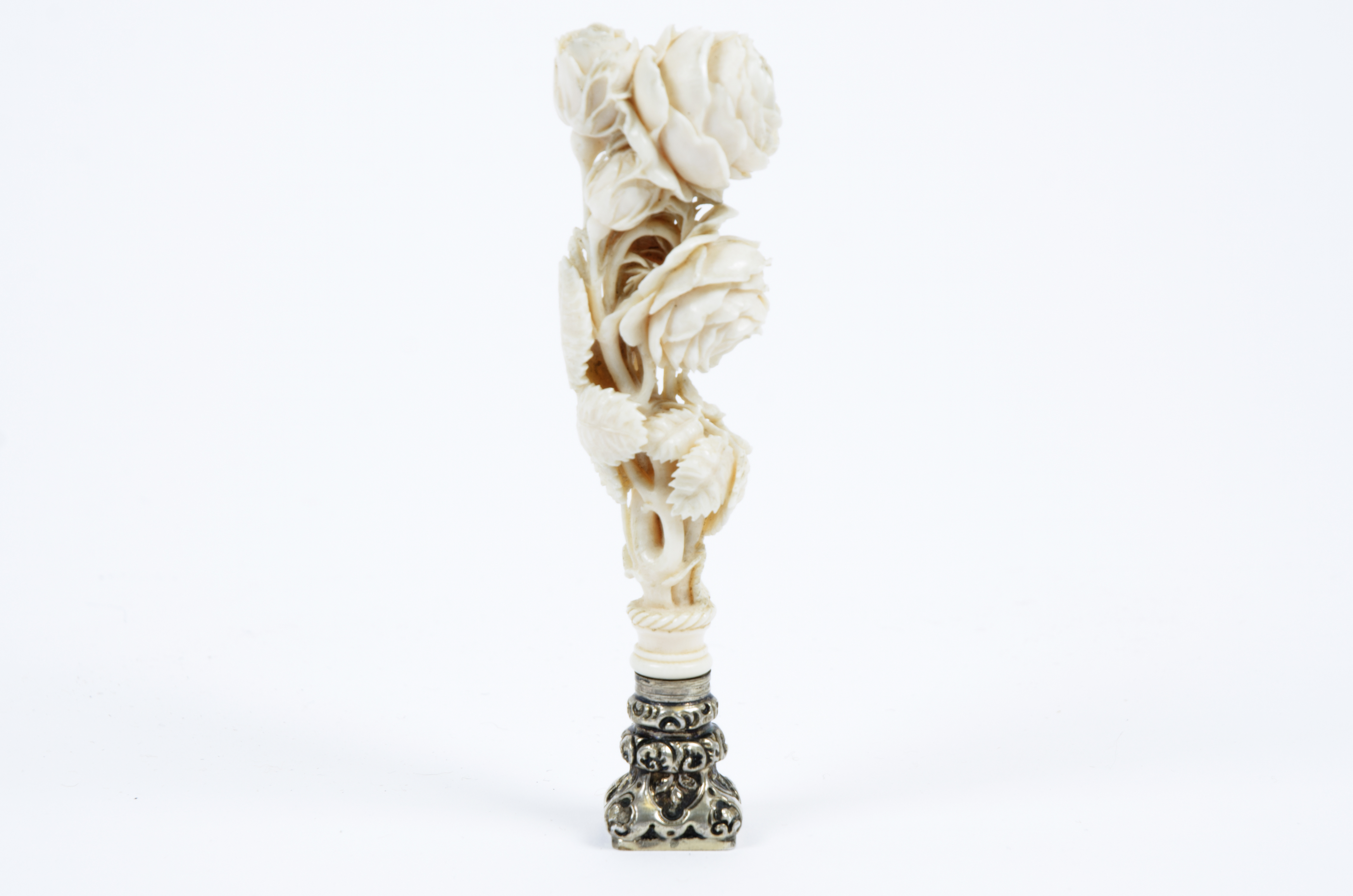 A 19th Century French carved ivory and silver desk seal, the handle carved as a bouquet of roses,