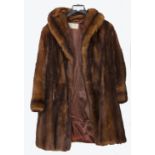 A 20th Century red brown mink three-quarter length coat, the brown silk lining bearing a label