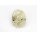 A late 19th Century Chinese jade brooch, the oval carved and pierced light coloured hardstone