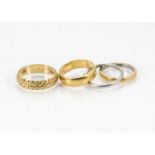 Four Art Deco and later wedding bands, one plain 22ct gold example, 4.5g, an engraved 18ct gold