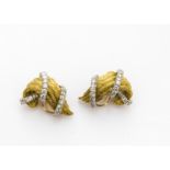 A pair of Kurt Wayne 18ct gold and diamond set ear clips, the textured scrolls with applied bands of