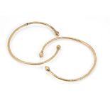 A pair of vintage Middle Eastern yellow metal bangles, each torsion style with pointed terminals and