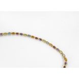 A modern 14ct gold and gem set bracelet, the line links set with garnets, peridots and citrines,