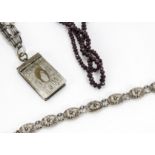 A late Victorian silver plated chain, supporting a silver plated vesta case, together a white