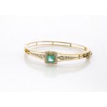 A certified emerald and diamond set gold bangle, the octagonal cut emerald in claw setting
