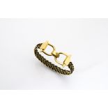 A contemporary 18ct gold plaited bangle, with buckle stirrup type clasp marked 750, internal