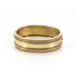 A Victorian gold bangle, oval form with one half plain, the other with neo-classical design, 23.