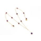 A mid 20th Century gold and amethyst necklace, having pendant to fringe and several colette set