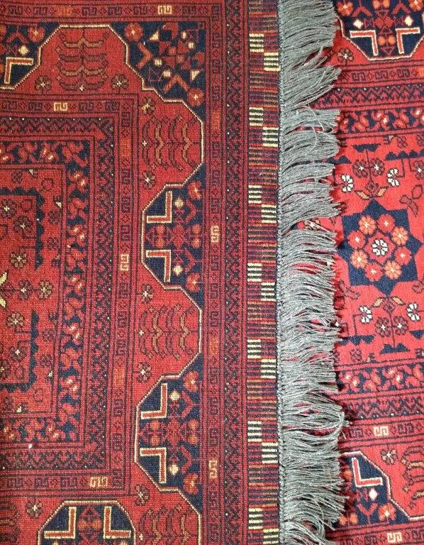 A Turkoman runner, the red ground with a row of nine shaped medallions surrounded by stylized flower - Image 3 of 3