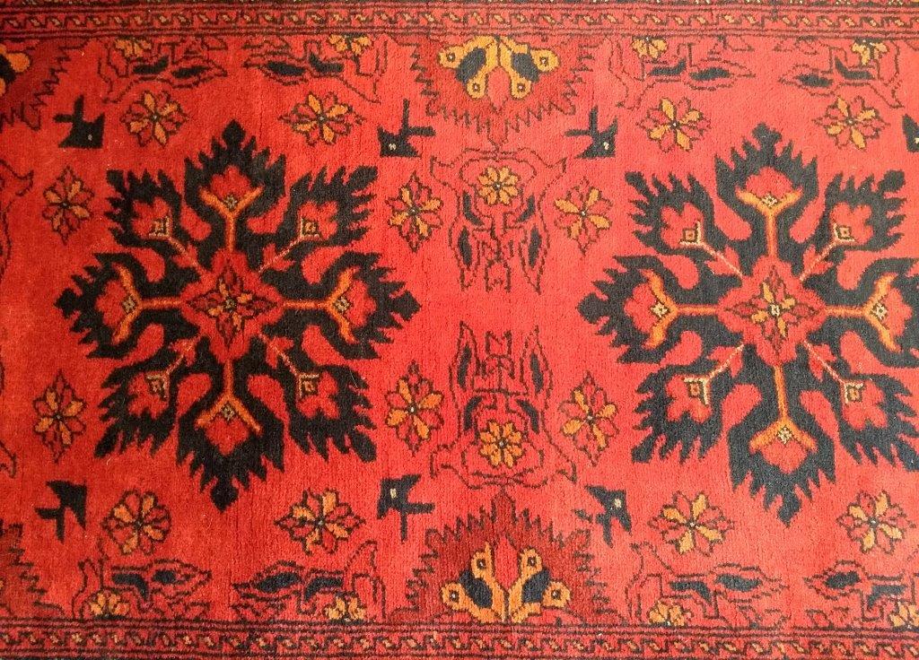 A woollen runner, single row of five motifs on red ground, within a rosette border, 85 cm x 285 cm - Image 3 of 3