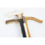 Four 19th and 20th Century walking sticks, ivory and horn handles with silver collars, and a