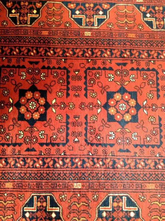 A Turkoman runner, the red ground with a row of nine shaped medallions surrounded by stylized flower - Image 2 of 3