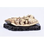 A 19th Century Japanese mammoth ivory carving of a wise man being brought offerings by his