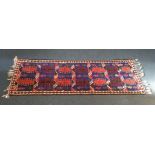 A 20th Century kilim runner, seven panels with comb decoration on blue ground, ivory border with