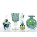 A collection of four Mdina items of glassware, including a horse headed paperweight, a vase, a scent
