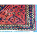 A Kazak woollen rug, central indigo pole medallion on red ground, indigo and ivory border, geometric