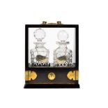 A modern brass bound two bottle tantalus, square ring-neck diamond-cut decanters with faceted