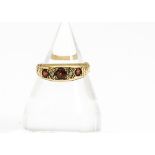 A garnet and diamond 18ct gold ring, the three circular mixed cut garnets set with rough cut