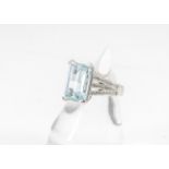 A contemporary aquamarine and diamond dress ring in 18ct white gold setting, the claw set step cut