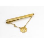 A 9ct gold and diamond set tie slide, from Shell Oil, the plain slide supporting a shell pendant set