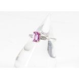 A contemporary pink sapphire and diamond 18ct white gold dress ring, the step cut pink sapphire in