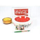A group of advertising items, including a Danish Coca-Cola glass dish, ashtrays for Carlsberg,