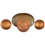 A copper oval tray, beaten centre, wave rim, by J. Pickard & Co, London; together with two African